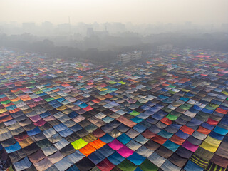 Aerial view of a vibrant tapestry of colorful fabrics spread across the landscape under a muted sky, Dhaka, Dhaka Division, Bangladesh.