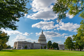 Naklejka premium Washington DC landmark. Senate and House in Washington DC. Capitol dome. Historic Capitol by the national flag. Capitol dome as symbol of law. Washington monument architecture. Washington DC