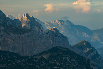 Aerial view of jagged peaks pierce the sky, touched by the sun's golden kiss, in the dramatic landscape of the Julian Alps, Tosc, Radovljica, Slovenia.