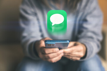 Receiving an Important Digital Message A Woman Holds a Phone While a Large Text Bubble Floats Above It