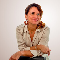 Smiling woman leaning on chair in studio