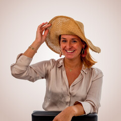 Smiling woman in straw hat posing in studio