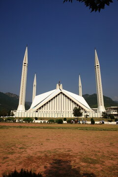 View of the majestic Faisal Mosque, its white marble facade gleaming under the clear blue sky, standing as a testament to architectural grandeur, Islamabad, Islamabad Capital Territory, Pakistan.