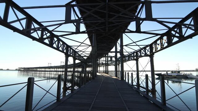 Monumental metal structure of the Muelle del Rio Tinto extending over calm water. Industrial heritage architecture, perfect travel and landmark shot.