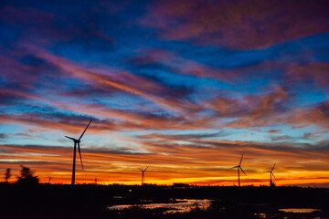 Fototapeta premium Sunset and Wind Turbine landscape over the Hainan Ring Expressway in Ledong County, Hainan, China, in autumn season
