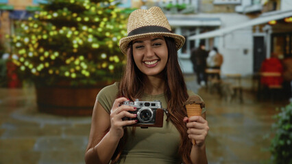 Woman smiling outdoors holding camera and ice cream cone with a vibrant festive background enhanced...