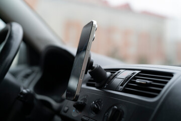 A smartphone is attached to the dashboard of a car while it provides navigation directions