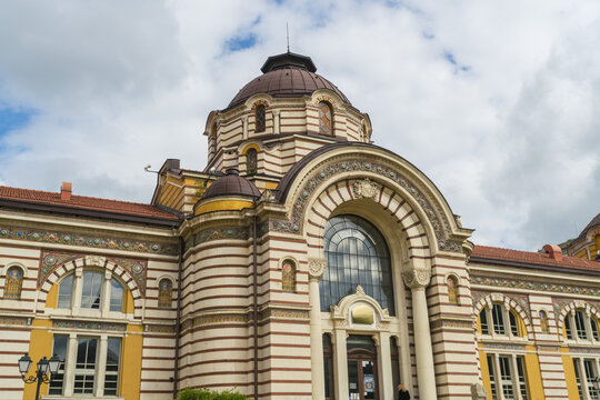 View of the Central Mineral Baths, a stunning architectural marvel with intricate striped facades and a prominent dome under a cloudy sky, Sofia, Sofia City Province, Bulgaria.