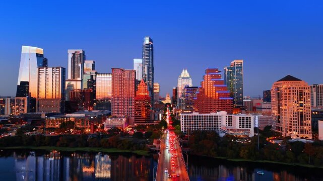 Bright panorama of Austin downtown at sunset time. View on the lively straight highway crossing the city and bridge over the Colorado River.