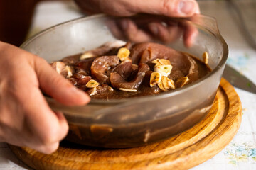 Detail shot of food preparation, mixing fresh meat with spices on a wooden cutting board base