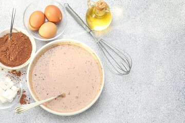 Chocolate dough, whisk and ingredients on grey textured table, flat lay. Space for text