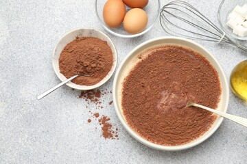Chocolate dough, whisk and ingredients on grey textured table, flat lay. Space for text