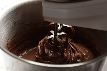 Mixing chocolate dough in bowl, closeup view
