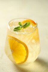 Refreshing spritzer cocktail with mint on light table, closeup