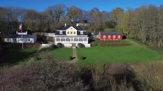 Scenic landscape with elegant buildings and lush greenery. The property includes traditional Danish architecture