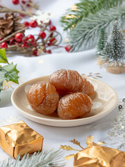 A plate of  French tradition candied chestnut or marron glacé with festive decoration and Christmas atmosphere.