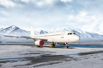 White passenger aircraft on the airport at winter on the background of scenic mountains