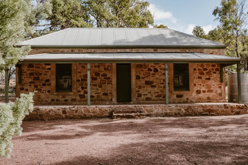 The building exterior of the old historic Wilpena Homestead house outdoor at daytime in the forest of Wilpena Pound during springtime season in the Australian outback in Flinders Ranges.