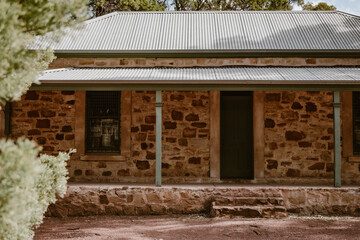 The building exterior of the old historic Wilpena Homestead house outdoor at daytime in the forest of Wilpena Pound during springtime season in the Australian outback in Flinders Ranges.