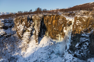 Frozen winter view of Magnusarfoss waterfall, Iceland.