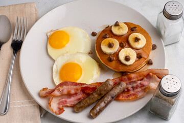 fried eggs with pancakes  , sausage and bacon