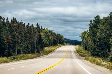 Scenic highway through dense green forest near La Tuque, Quebec