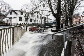 Flooded bench and table near river in M&ouml;lndal, Sweden during heavy rainfall