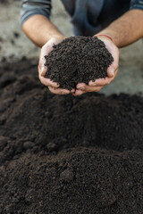 Soil in a man hands. Selective focus.