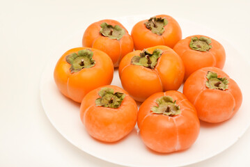 Orange persimmon fruits. Ripe persimmon on a plate.