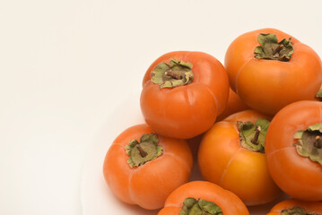 Orange persimmon fruits. Ripe persimmon on a plate.