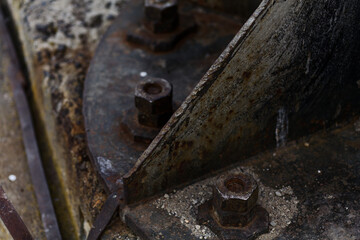 Rusted Industrial Machine: Corroded Hexagonal Bolts on Old Metal Plate, Vertical Close-Up