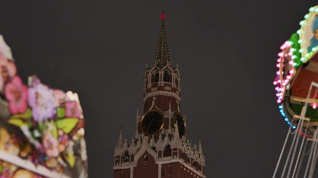 Spasskaya Tower of Moscow Kremlin towering over amusement park at night