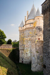 Detail of the towers of impressive medieval castle of Vitr&eacute; and its moat, Brittany, France. Background with copy space, sunny and bright summer day.