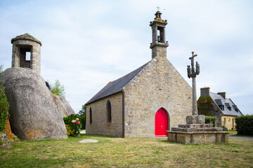 Chapelle Pol, a small granite church in Brignogan-Plages, and the nearby calvary cross and sentry box carved in the rock. Finistere, Brittany, France.