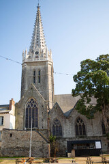 The bell tower of the gothic Notre Dame cathedral in Vitr&eacute;, Brittany, France. View from the benedectine garden. Vertical shot, sunny and bright summer