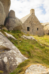 The famous 17th-century guardhouse stuck between two granite rocks, located in the old fishermen village of Meneham, Brittany, France. Side view 