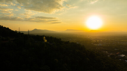Aerial view at sunset above the Mekong river in Laos revealing Pakse city golden giant buddha