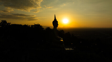 Aerial view at sunset above the Mekong river in Laos revealing Pakse city golden giant buddha