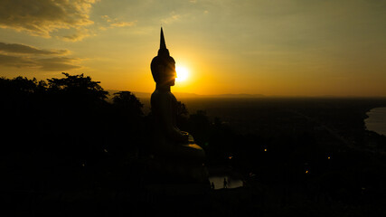 Aerial view at sunset above the Mekong river in Laos revealing Pakse city golden giant buddha