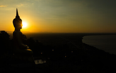 Aerial view at sunset above the Mekong river in Laos revealing Pakse city golden giant buddha