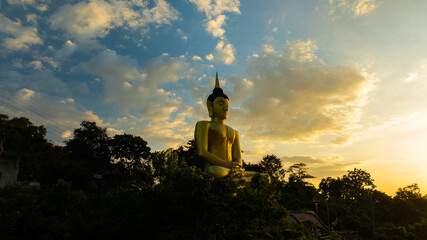 Aerial view at sunset above the Mekong river in Laos revealing Pakse city golden giant buddha