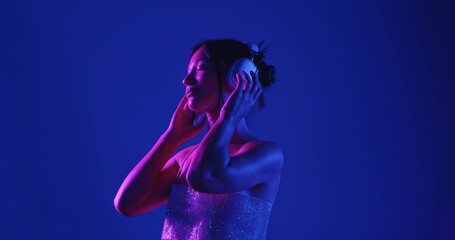 Woman Enjoying Music in Headphones with Neon Lighting