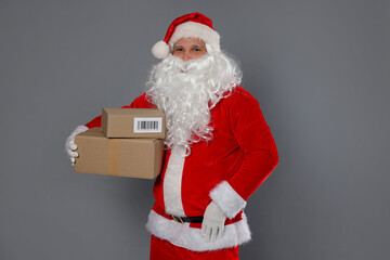 Santa Claus with parcels on grey background