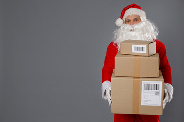 Santa Claus with parcels on grey background, space for text