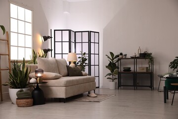 Stylish living room with sofa and houseplants. Interior design