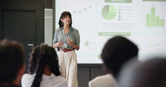 Business woman, graphs and presentation for strategy in seminar room with audience. Training, forum speech and statistics with corporate growth for public speaking, education and convention for crowd