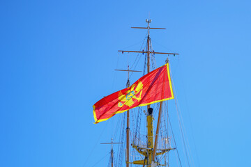 Flag of Montenegro on mast of sailboat against blue sky. Montenegro, Tivat