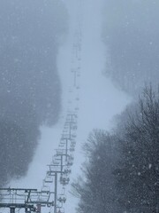 Ski lift ascending into the misty snow