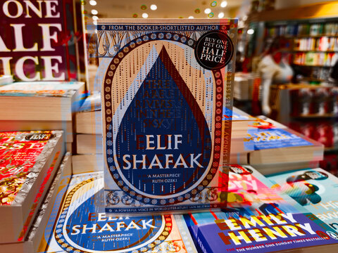 Elif Shafak book on display in bright bookstore with colorful covers and stickers