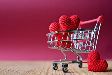 The red Heart shapes in shopping cart on red background , love concept for shopping on valentines day